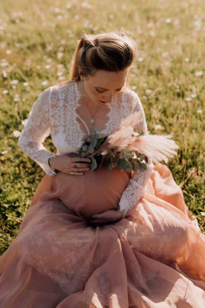 Maternity photo session - Grace and Chris-7 Expecting mum is sitting on the grass and looking down at her bump. Maternity photo session out of this world. Maternity photoshoot. Ewa Jones Photography