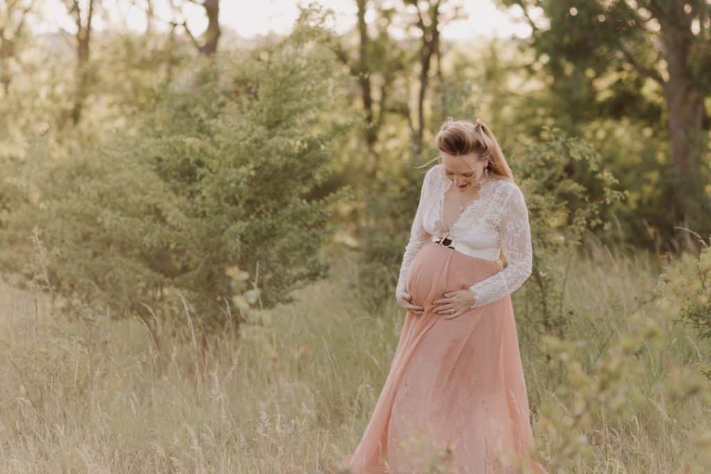 Maternity photo session - Grace and Chris-9 expecting mum is looking down at her bump. Maternity photo session in the wild field. Maternity photo shoot in Hampshire. Basingstoke photographer. Ewa Jones Photography