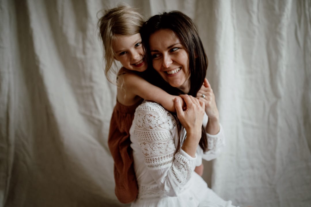 Mum is looking towards her daughter. daughter is cuddling her. natural lifestyle family photography in Hampshire. Ewa Jones photography. Photographer in Basingstoke. Hampshire photographer. family photographer in Hampshire