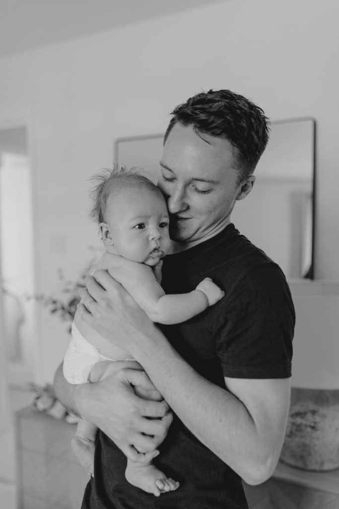 daddy is cuddling his baby boy. newborn photo shoot in Hampshire. Hampshire photographer. Ewa Jones Photography