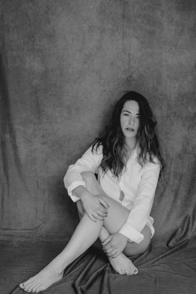 female is sitting and looking at the camera. she is wearing white shirt. Lovely female intimate photo session in Basingstoke. Hampshire female photographer. Ewa Jones Photography