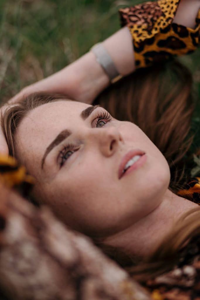 female is laying on the grass and looking towards the sky. how to pose. female model phot session. female model portfolio. Hampshire lifestlye photographer. Ewa Jones Photography