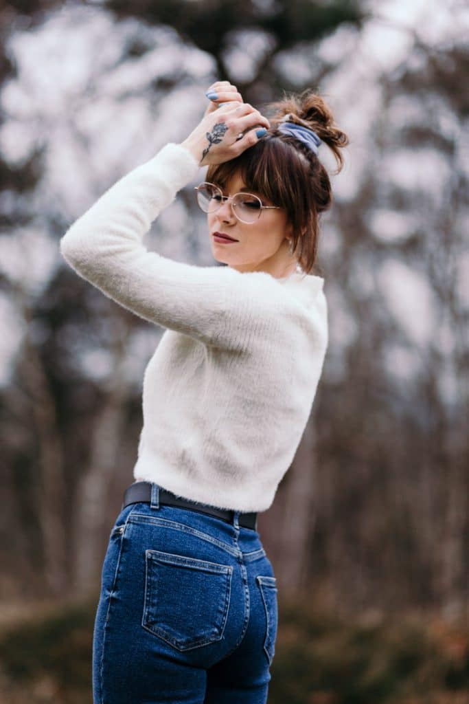 female is wearing a white jumper and blue jeans. she is standing and has her eyes closed. Emowering female photo sessions in Hampshire. Hampshire photographer. Ewa Jones Photography
