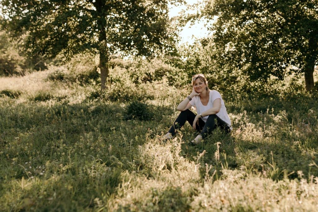 Female is sitting on the grass and smiling. Empowering female photo sessions. Female photo session in Basingstoke hamsphire. Hampshire photographer. Basingstoke female photographer.Ewa Jones Photography