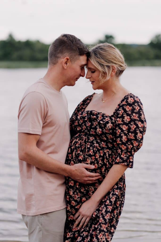 Expecting couple is cuddling and standing close to each other. Lovely natural lifestyle maternity photo session. Hampshire photographer. Ewa Jones Photography. Bump and newborn photo session