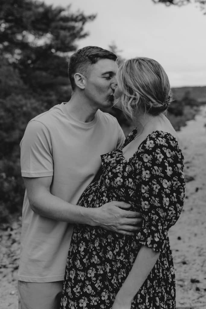Expecting parents are kissing and cuddling. Lovely maternity photo session in Hampshire. Natural photography. Ewa Jones Photography