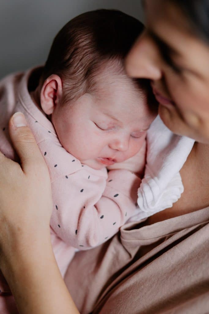 Mum is cuddling close her newrborn baby. Newborn baby posing ideas. Newborn photoshoot in Basingstoke. Ewa Jones Photography