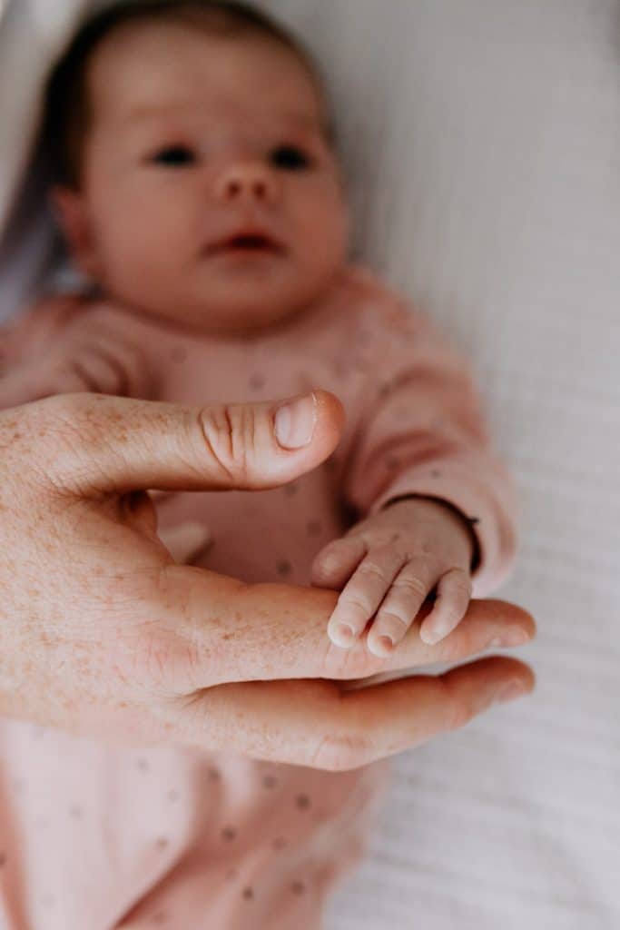 CLose up detail of newborn baby hands. dad is holding newborn baby hand. Newborn photoshoot in Basingstoke. Ewa Jones Photography