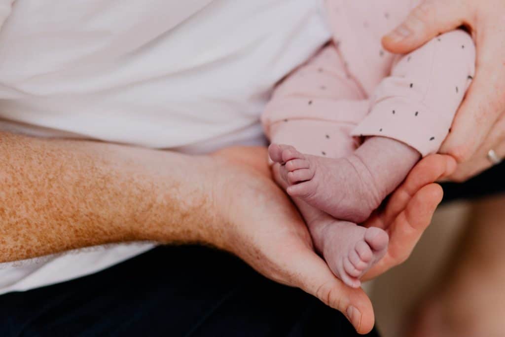dad is holding his newborn baby feet. Basingstoke newborn photographer. Ewa Jones Photography