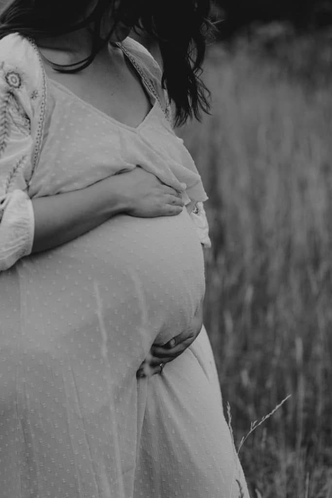 pregnant mum is holding baby bump and looking down. Lovely intimate maternity photo shoot in Hampshire. Maternity photography in Basingstoke. Ewa Jones Photography