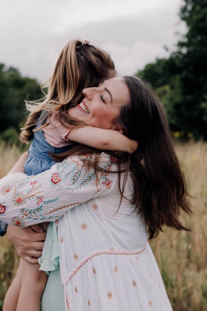 Mum is hugging close her little girl. Maternity photo shoot with a toddler. Maternity photographer in Basingstoke Hampshire. Ewa Jones Photography