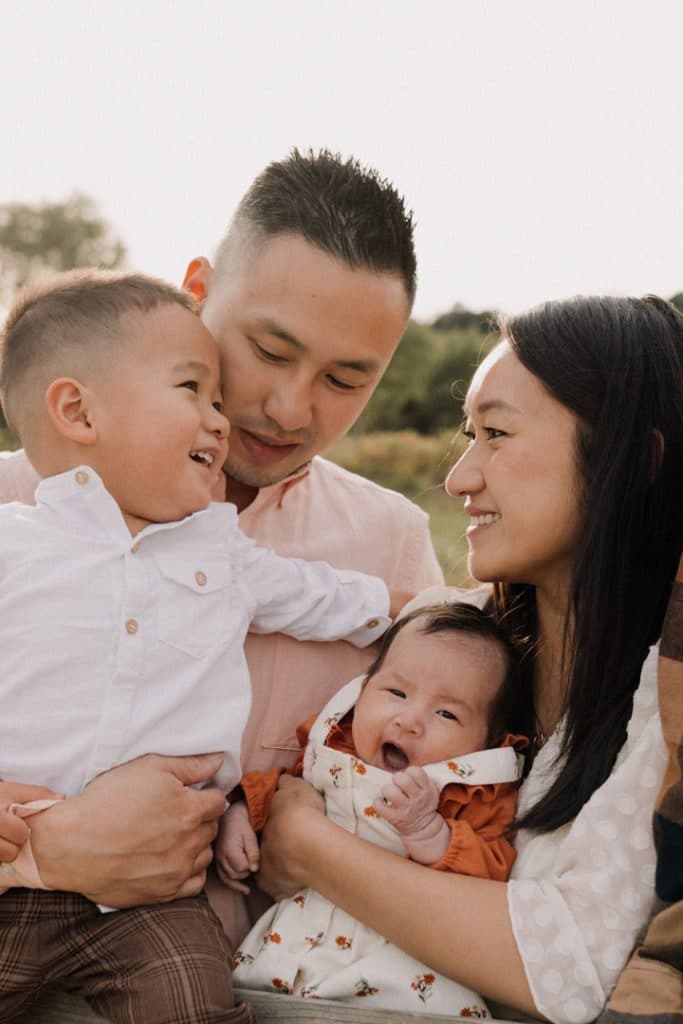 family of four is looking at each other and cuddling. Lovely late summer family photo session. Hampshire family photographer. Basingstoke photographer. Ewa Jones Photography