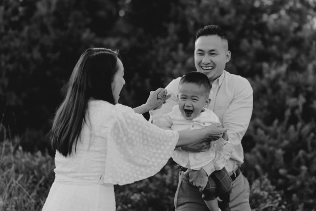 Mum and dad are doing swing with their toddler boy. he is so happy. family photoshoot in surrey. Hampshire photographer. Ewa Jones Photography family photo session in September