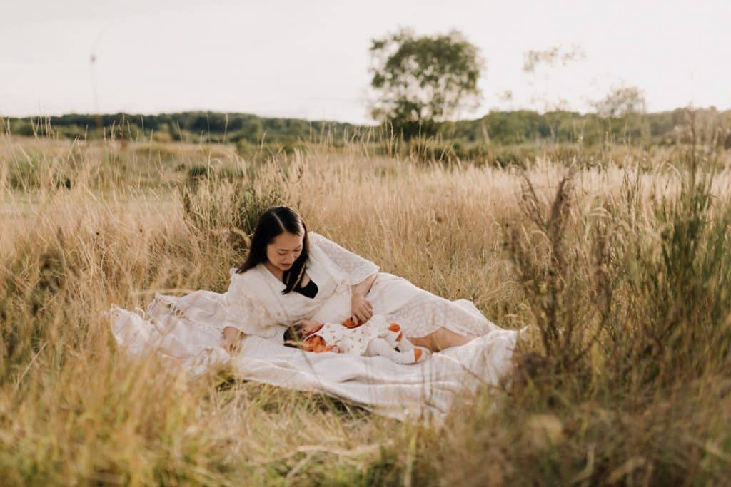 Mum is laying on the blanket and looking at her baby girl. lovely late summer outdoor family photo session. Family photographer in Hampshire. Ewa Jones Photography