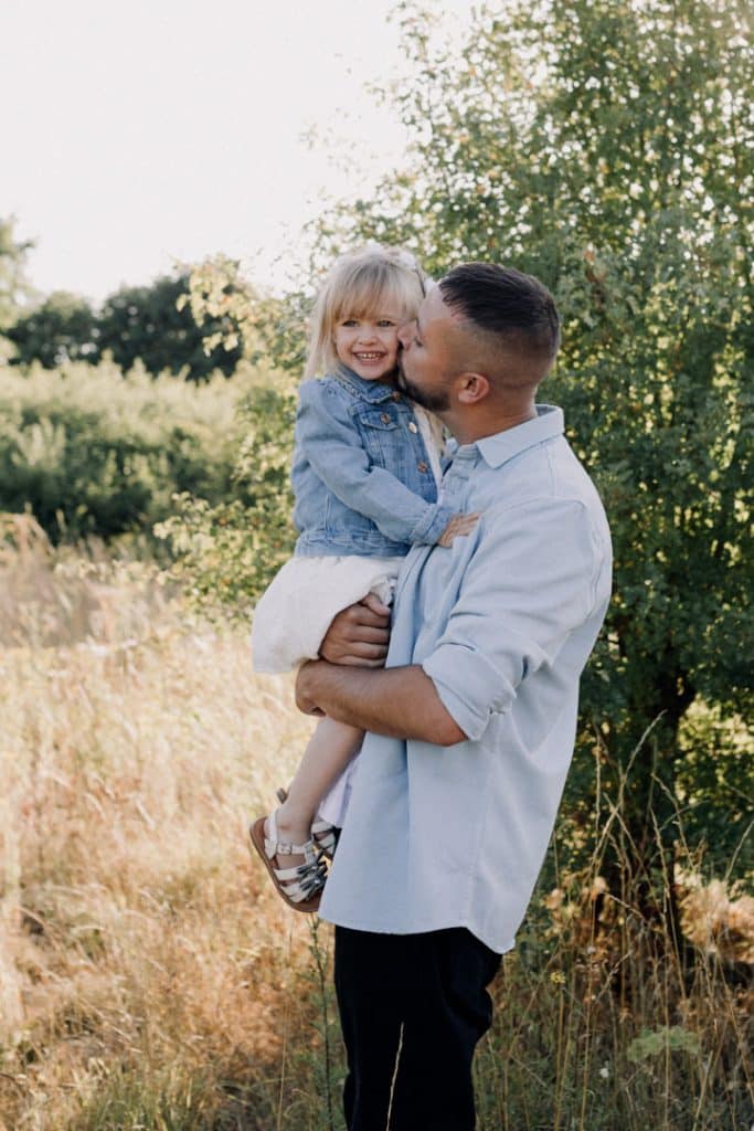 Dad is standing in the field and kissing his girl. Lovely family photo session in Basingstoke. Hampshire family photographer. Ewa Jones Photography