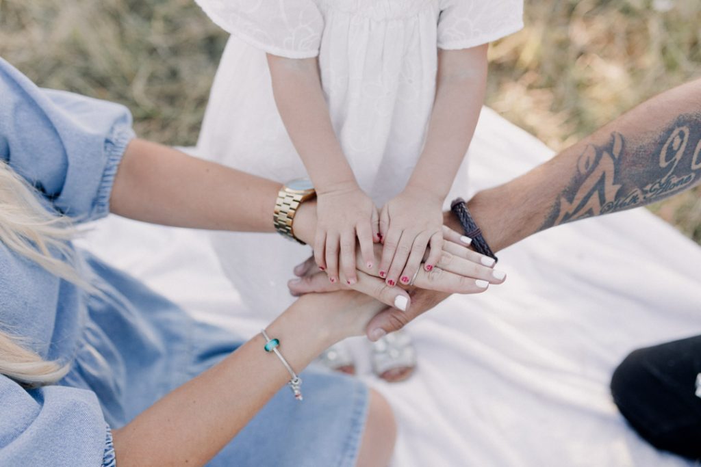family of three is holding hands. lovely natural family photo session. Hampshire photographer. Ewa Jones Photography