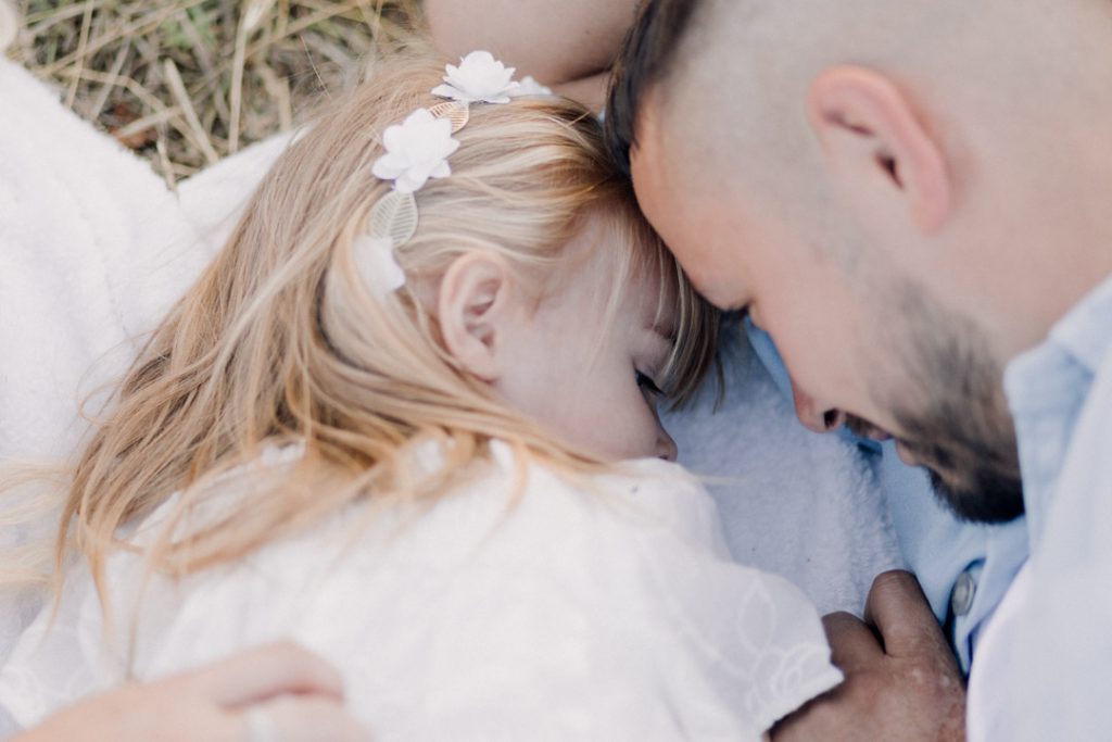 close up of daddy and daughter cuddles. Basingstoke family photographer. lovely cuddles and kisses. family photo session in the summer. natural family photography. Hampshire family photographer. Ewa Jones Photography