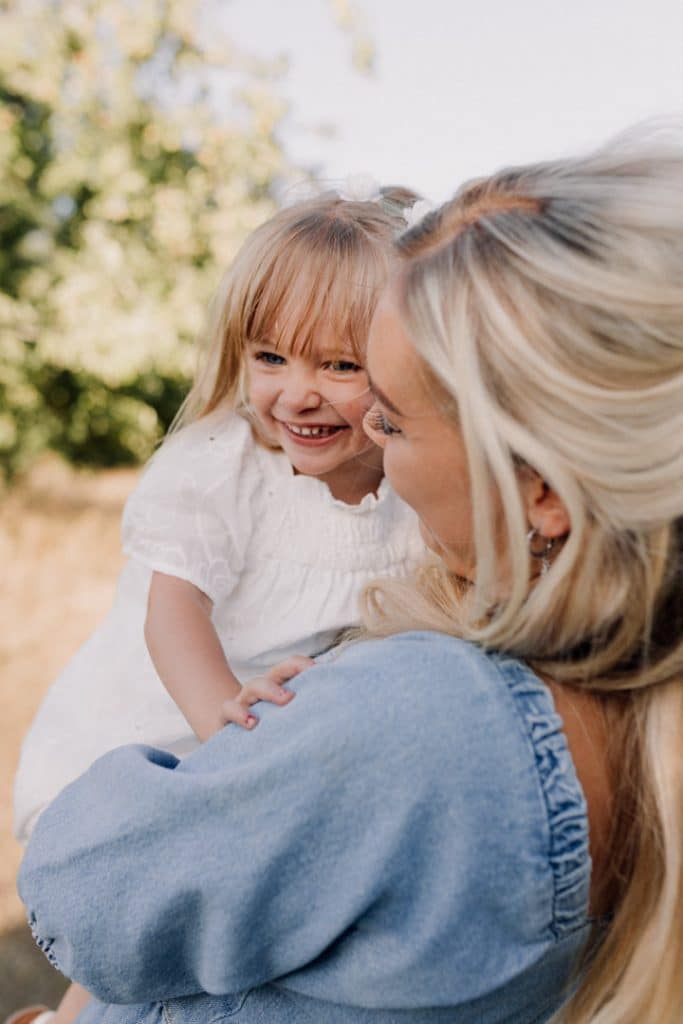 Mum is holding her girl and looking at her. family poses for family photo session. Summer family photo shoot. Hampshire family photographer. Ewa Jones Photography