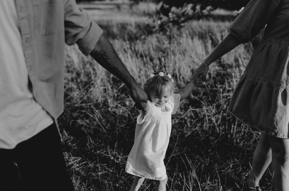 mum and dad are holding their girl and she is smiling. hampshire photographer. Family photographer. Ewa Jones Photography. laugh giggles and happiness