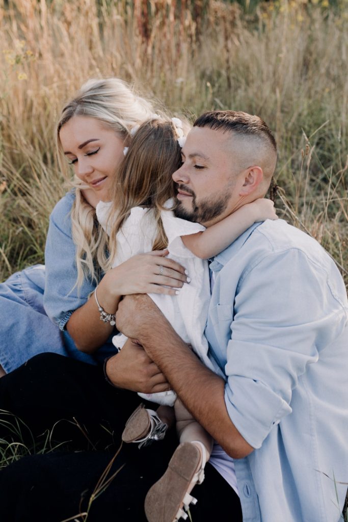 family of three is cuddling. lifestyle family photo shoot in Basingstoke. Basingstoke photographer. Hampshire family photographer. Ewa Jones Photography