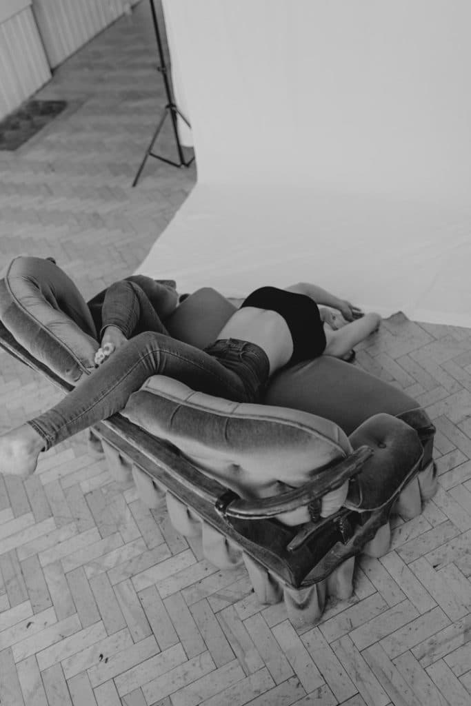 Female is laying on the couch and looking down to the floor. Model portfolio. Model photo session. Hampshire model photographer. Ewa Jones Photography