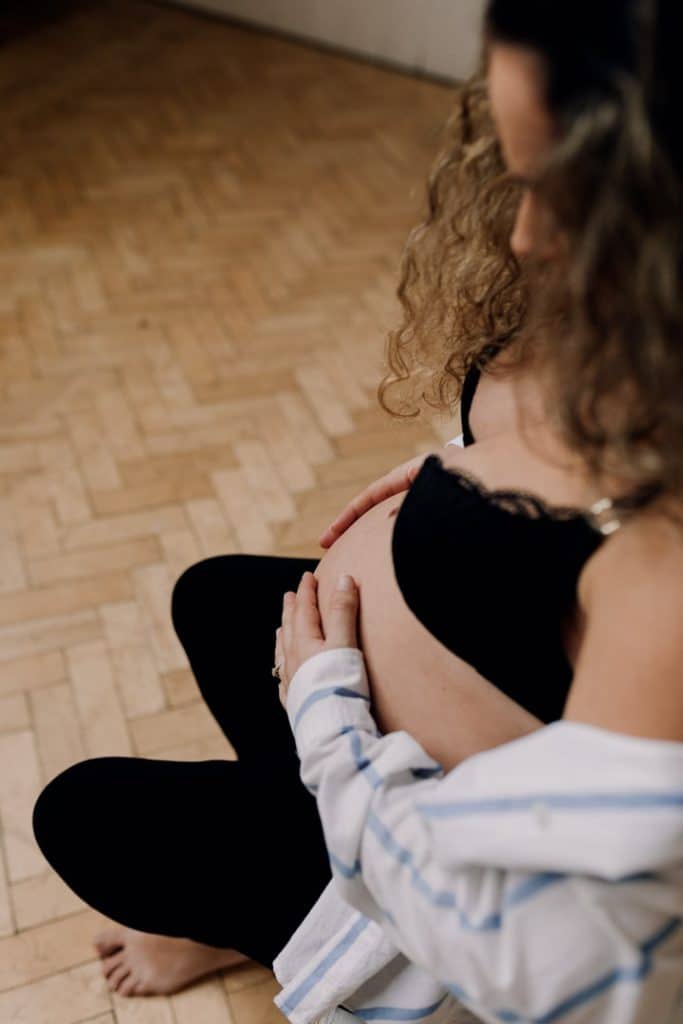 Maternity photo session in Basingstoke. Female photo shoot in Hampshire. Female is sitting on the chair and holding her bump. Basingstoke maternity photographer. Ewa Jones Photography