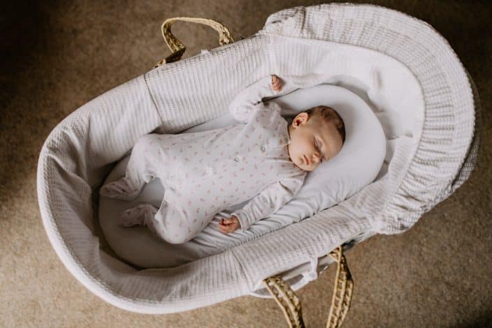 Baby girl is laying in moses basket and sleeping. Newborn photo session in Hampshire. Hampshire newborn photographer. Ewa Jones Photography