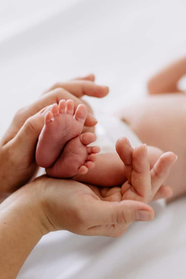 Mum is holding newborn baby feet. Close up detail of a newborn baby toes. Newborn photography in Hampshire. Ewa Jones Photography
