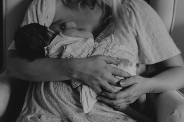 Mum is breastfeeding baby girl. Newborn photo shoot in London. Candid newborn photography. Basingstoke newborn photographer. Ewa Jones Photography