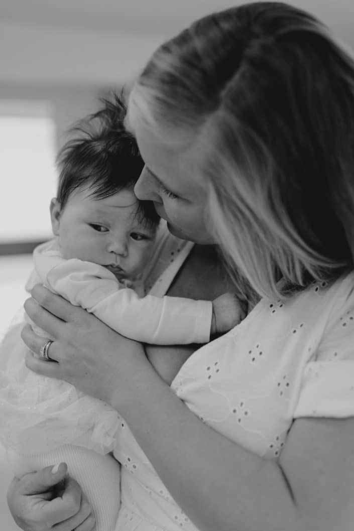 Mum is kissing her baby girl. candid photo shoot in Hampshire. Newborn photographer in Basingstoke. Ewa Jones Photography