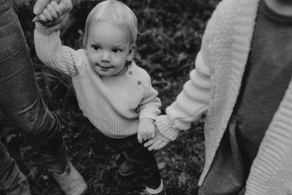Black and white image of a little boy holding hands with his mum and his sister. family photo session in the autumn. family photographer in Hampshire. Basingstoke photographer. Ewa Jones Photography