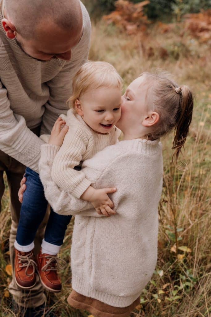 Sister is cuddling her baby brother. lovely natural family moments. Family photographer in Basingstoke. Ewa Jones Photography