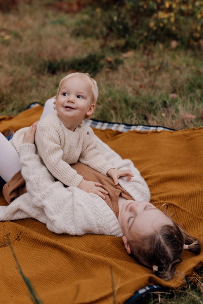 Baby brother and sister are cuddling on the blanket. lovely autumn family photo sessions. Autumn clothes for family photo session. Ewa Jones Photography. Hampshire photographer