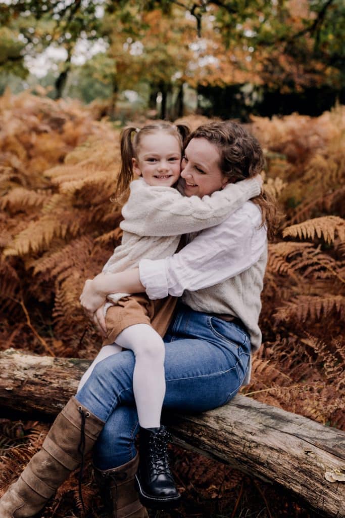 Mum is cuddling her daughter. Woodland family photo session in the autumn. family photographer in Basingstoke Hampshire. Hampshire photographer. Ewa Jones Photography