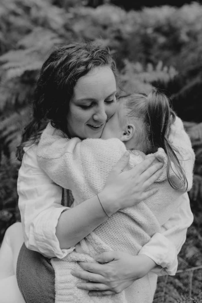 Mum is cuddling her daughter. Woodland family photo session in the autumn. family photographer in Basingstoke Hampshire. Hampshire photographer. Ewa Jones Photography
