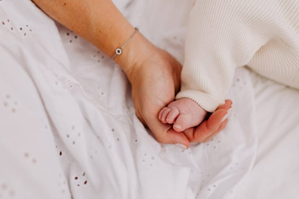 Close up detail of mum holding baby daughter foot. newborn photo session details. Hampshire newborn photographer. Ewa Jones Photography.