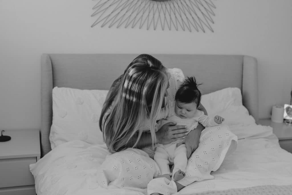 mum is holding in her arms her newborn girl. Hampshire photoshoot. Ewa Jones Photography