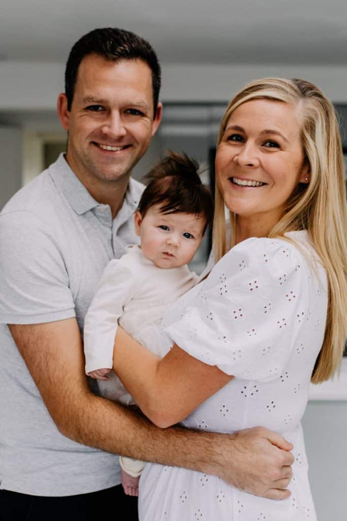 Mum and dad are cuddling their baby girl close. Hampshire family photo session. Newborn photographer in Hampshire. Ewa Jones Photography.