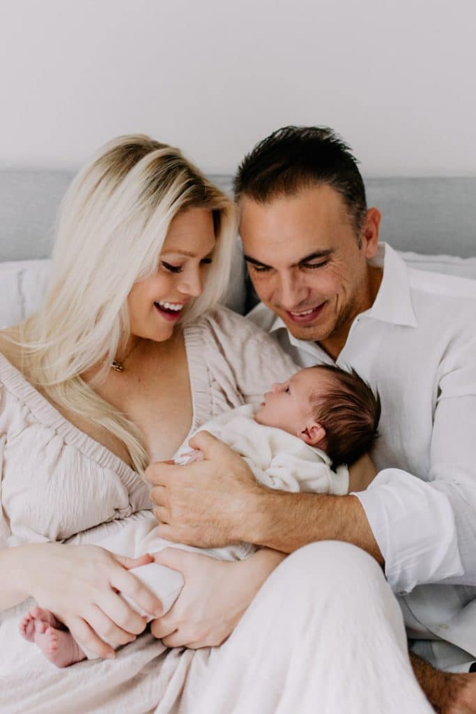 Newborn photo shoot in London-10 mum and dad are holding their newborn girl in their arms. Natural family photo session. Newborn photo session in London. Hampshire newborn photographer. Ewa Jones Photography