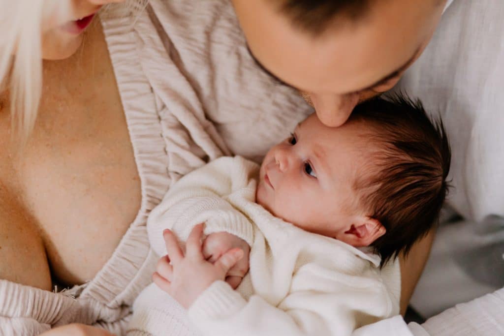 Newborn photo shoot in London-11 Dad is kissing his newborn baby girl. lovely candid photograph. London family. Newborn session. Hampshire photographer. Ewa Jones Photography