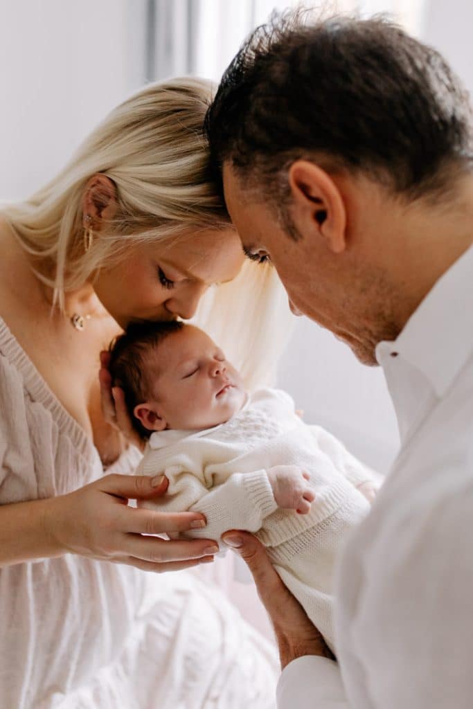 Newborn photo shoot in London-17 Mum is kissing her newborn baby girl. Newborn photo session in London. Family photographer. Ewa Jones Photography