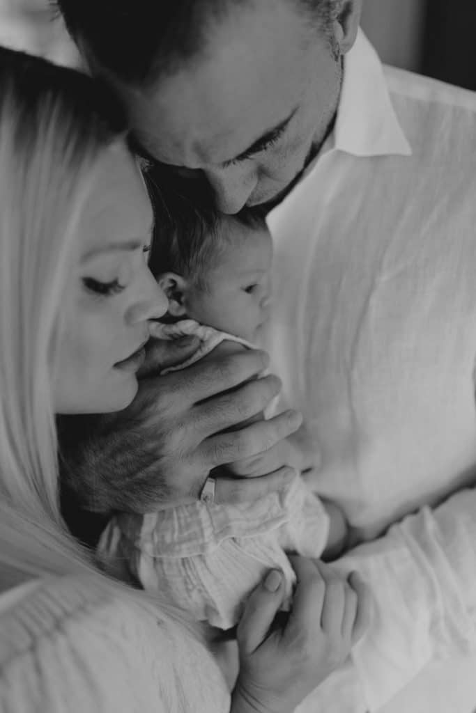 Newborn photo shoot in London-27 Mum and dad are cuddling their newborn baby girl close. natural lifestyle photo shoot. London newborn photography. Ewa Jones photography.