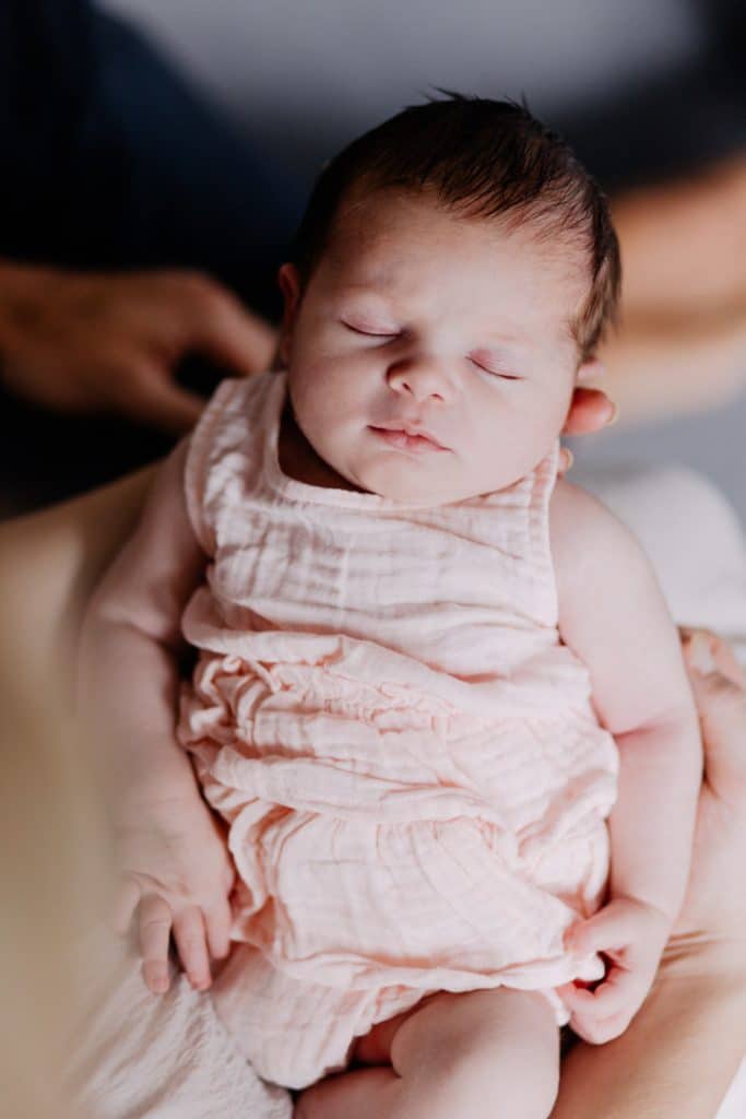 Newborn photo shoot in London-32 baby girl is sleeping. She is wearing lovely pink baby grow. Newborn photo shoot in London. Hampshire newborn baby photographer. Ewa Jones photography.