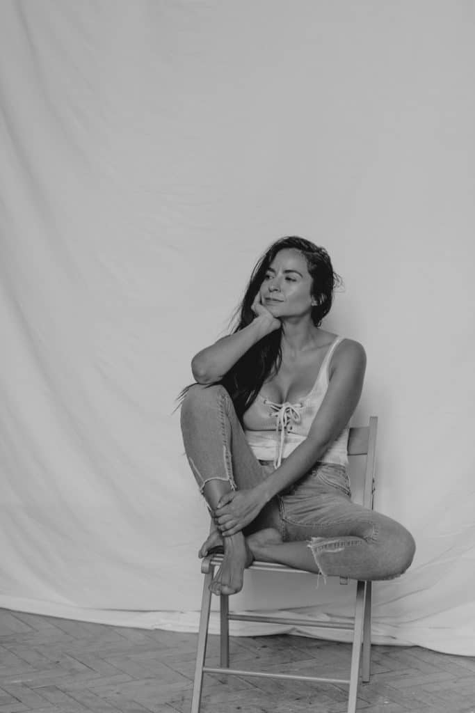 Female is sitting on the chair and looking away. woman photo shoot in the studio. Hampshire photography. Ewa Jones Photography