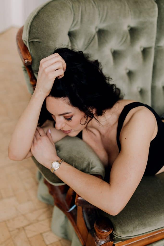 Empowering female sessions-27 Model portfolio. Model photo sessions in Hampshire. Female is laying on the sofa and looking down. intimate photo shoot. Ewa Jones Photography