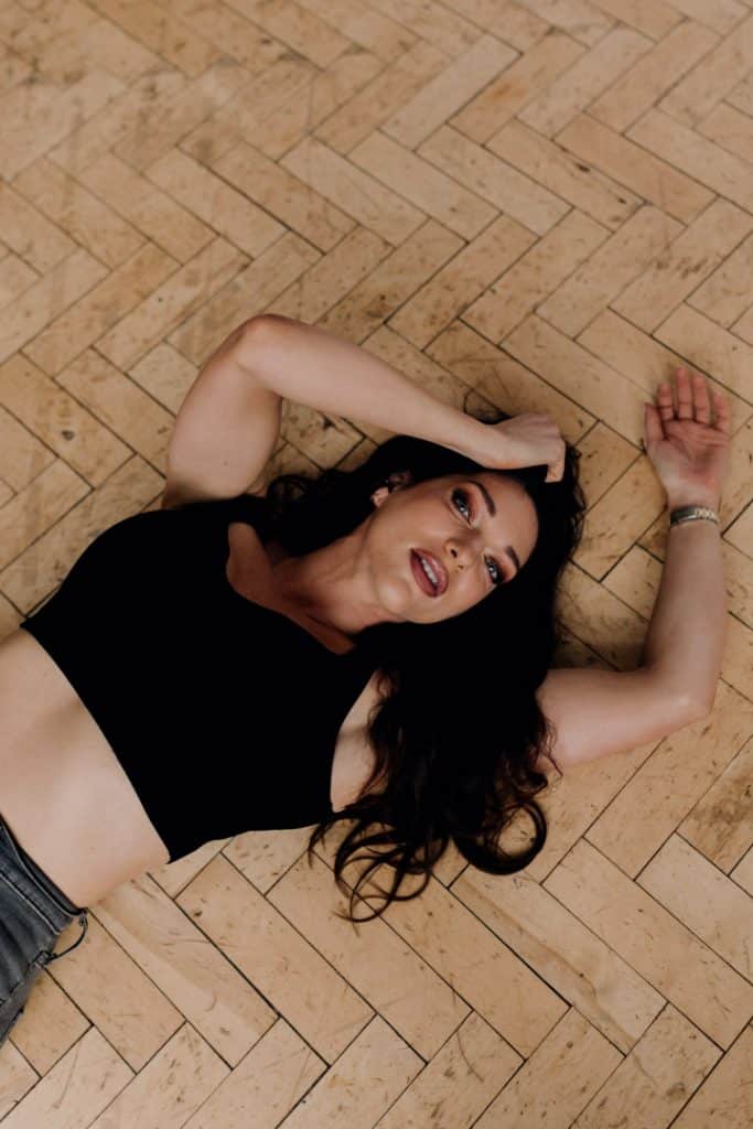 Empowering female sessions-30 Female is laying on the floor and looking at the photographer. Women photo shoot in the studio. Ewa Jones Photography