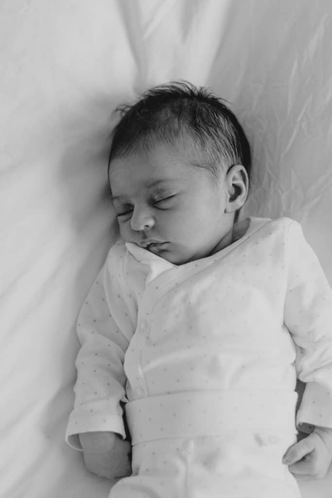 Baby girl is laying on bed and sleeping. Peaceful newborn photo session at home. Hampshire newborn photography. Ewa Jones Photographer