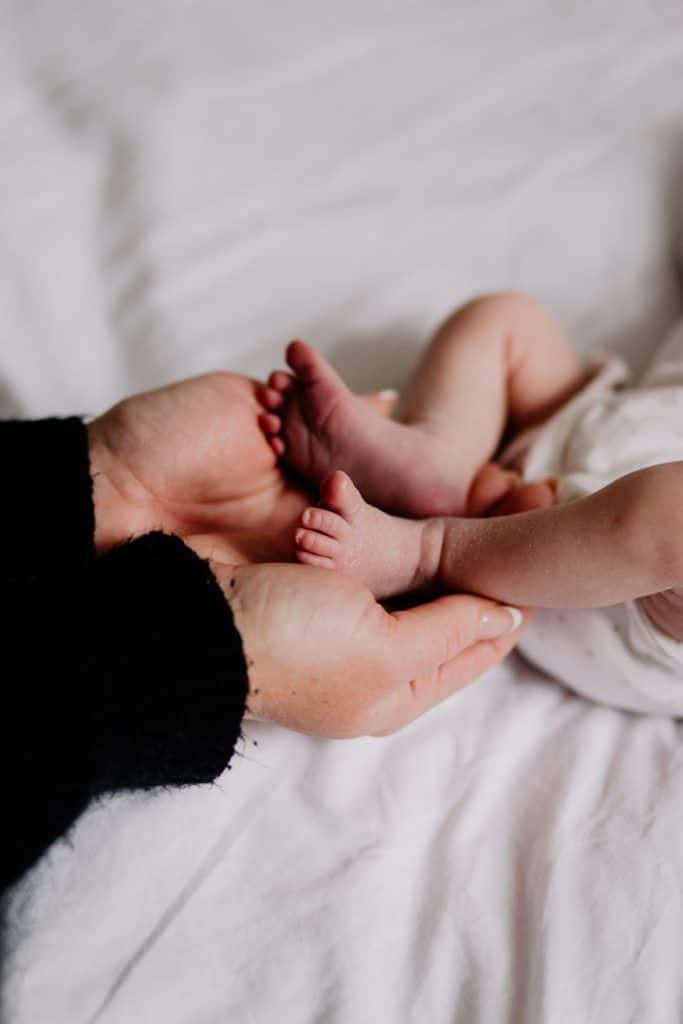 mum is holding newborn baby girl feet. Newborn photo session in Hampshire. Ewa Jones Photography