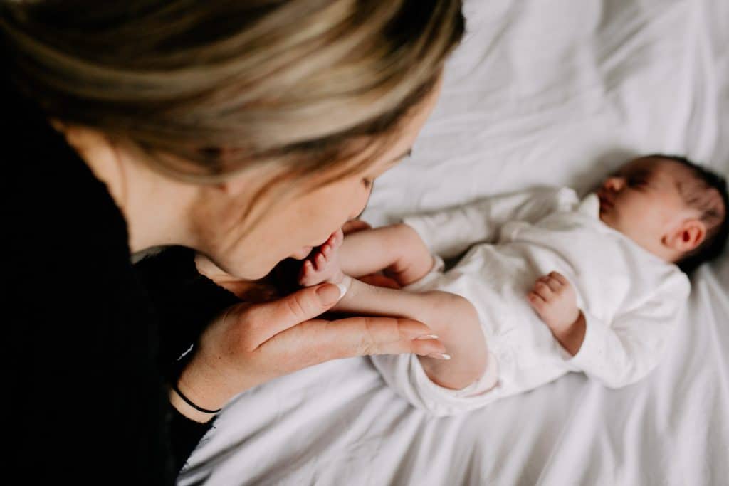 mum is kissing newborn baby girl feet. lovely natural moment of motherhood. Hampshire photographer. Ewa Jones Photography