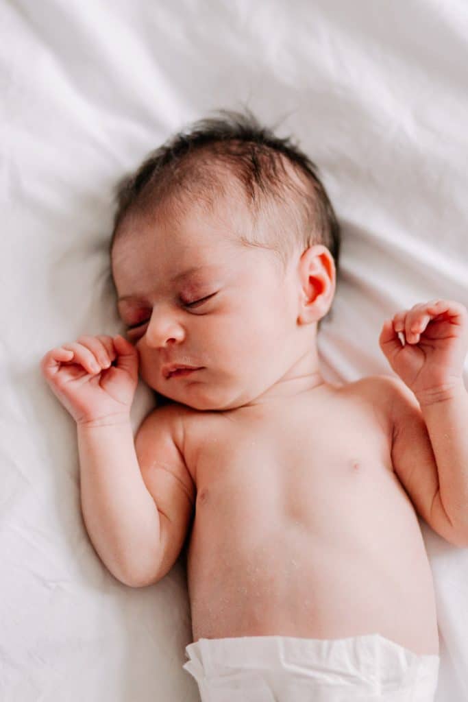 newborn baby girl is sleeping on the bed. tiny babies. basingstoke family photographer. Ewa Jones Photography